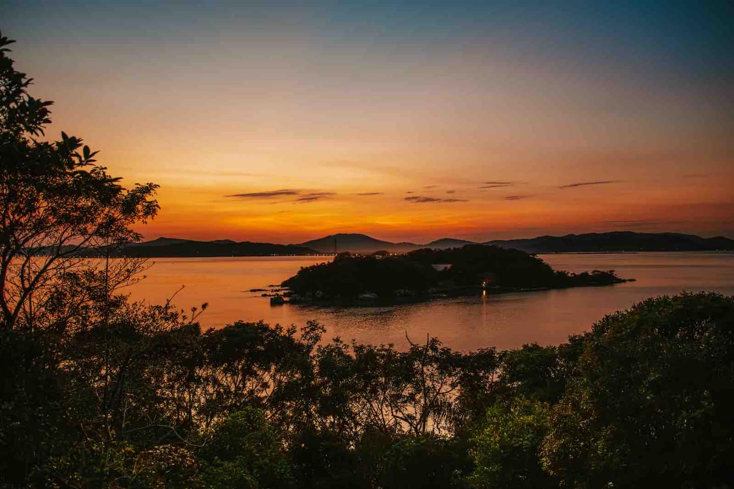 Pôr do sol sobre a baía visto da mata