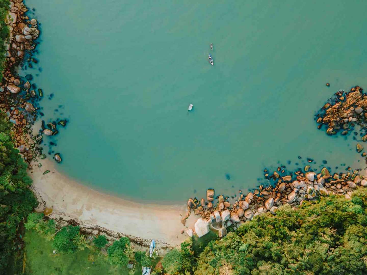 Vista aérea de uma enseada de areia clara e pedras