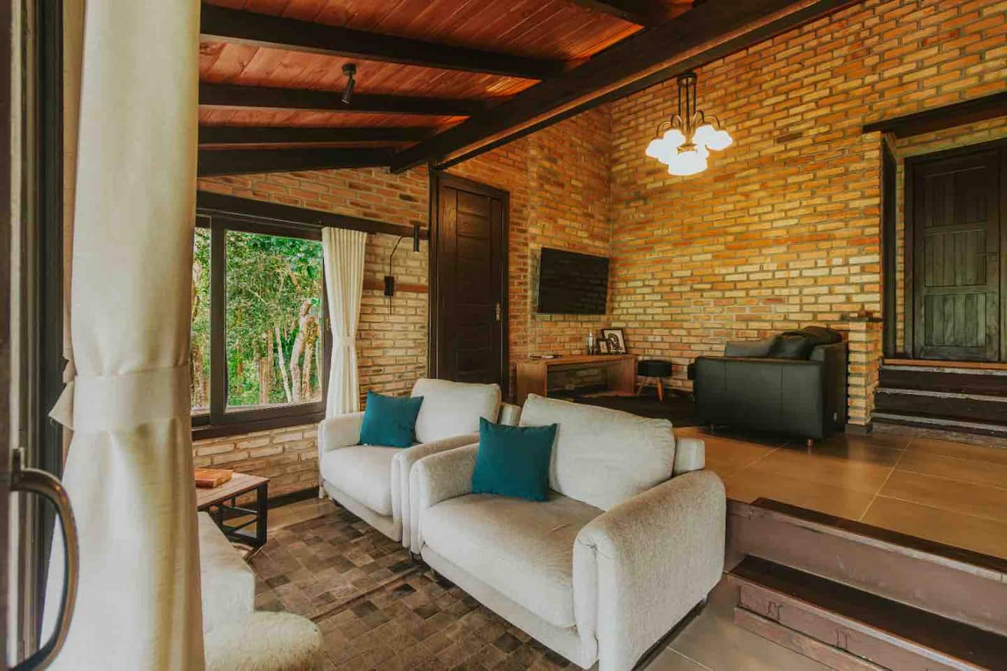 Sala integrada com lareira e paredes de tijolo